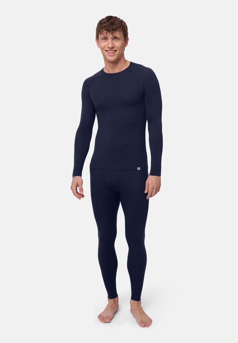 Dunkelblaues langärmeliges Thermo-Oberteil und passende Leggings aus einem dehnbaren, gerippten Stoff, mit figurbetontem Schnitt und minimaler Markenkennzeichnung.