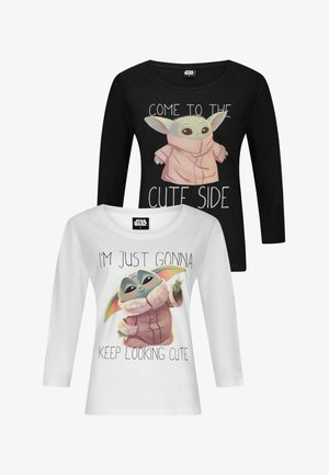 Twee langmouwige shirts: één zwart met een personage en de tekst "Kom aan de schattige kant," en één wit met "Ik blijf gewoon schattig kijken."