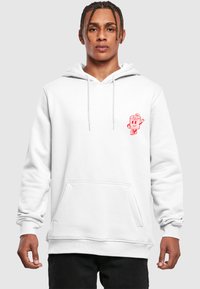 Hvit hettegenser med lommer foran, med en rød tegneseriefigur brodert på venstre bryst. Stoffet ser mykt ut, med en avslappet passform.