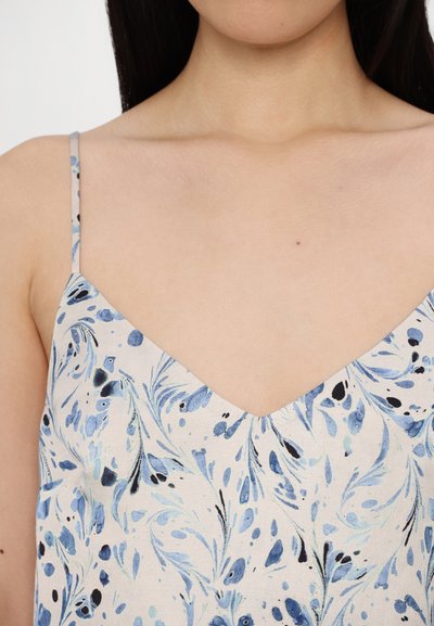 Blue and black floral patterned fabric with a V-neck design and thin straps, featuring a soft texture and light background color.