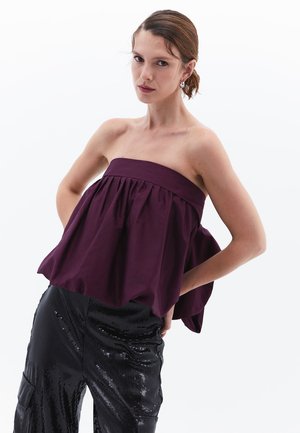 Bordeaux strapless top met geplooid ontwerp, gecombineerd met zwart paillettenbroek. De top heeft een brede halslijn en een vloeiende vorm.