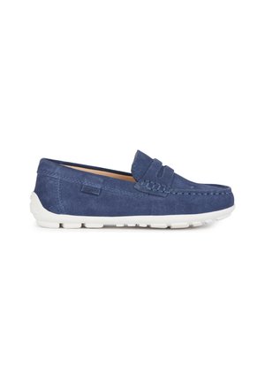 Mocassins en suède bleu marine avec une semelle en caoutchouc blanc, présentant un design cousu et un panneau d'accent latéral pour plus de détails.