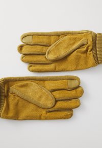 Gants jaunes en tissu texturé avec paume et doigts rembourrés, poignet à côtes et accents en cuir sur les pointes des doigts pour plus de durabilité.