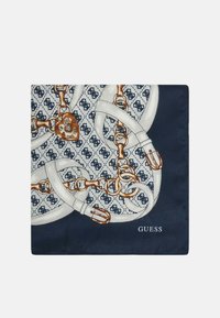 Vierkante zijden sjaal met een marineblauwe achtergrond met witte en gouden kettingpatronen en een hartvormige slotdetail. "GUESS" logo in de hoek.