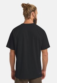 T-shirt nera a maniche corte con una texture liscia e maniche raglan, caratterizzata da un collo rotondo e una vestibilità rilassata, adatta per l'abbigliamento casual.