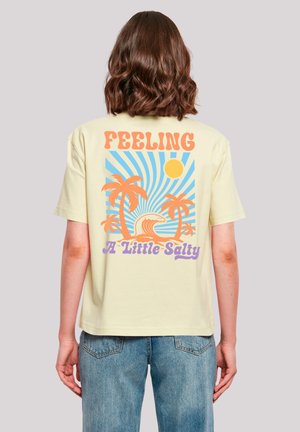 Gelbes T-Shirt mit kurzen Ärmeln, das ein farbenfrohes Grafikdesign von Palmen, einer Welle und der Sonne zeigt, mit dem Text "Feeling A Little Salty".
