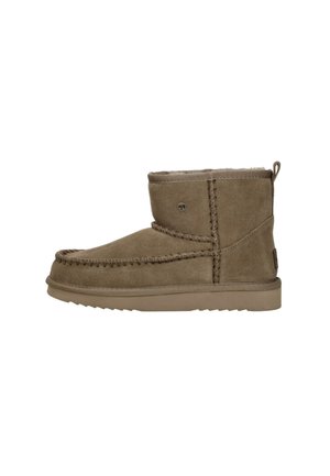 Bruine suède enkelboot met stiksels, zachte bontvoering, platte rubberen zool en een klein logo aan de zijkant.