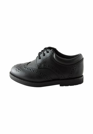Schwarzer Brogue-Lederschuh mit dekorativen Lochmustern, Schnürung vorne, niedrigem Absatz und abgerundeter Spitze, von der linken Seite auf weißem Hintergrund gezeigt.