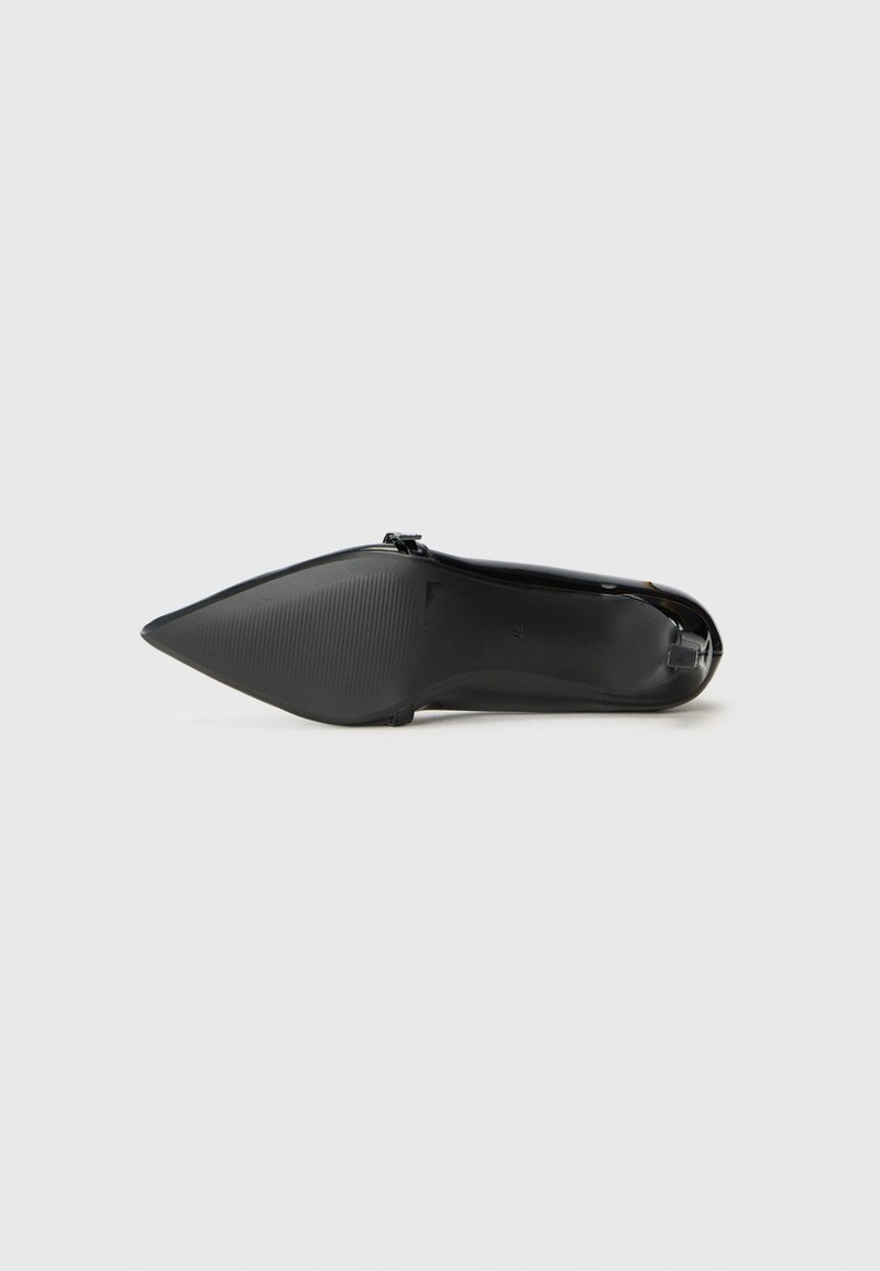Zapato de tacón alto negro con punta afilada y acabado brillante, suela texturizada y acentos de hardware mínimos, presentando un diseño elegante y moderno.