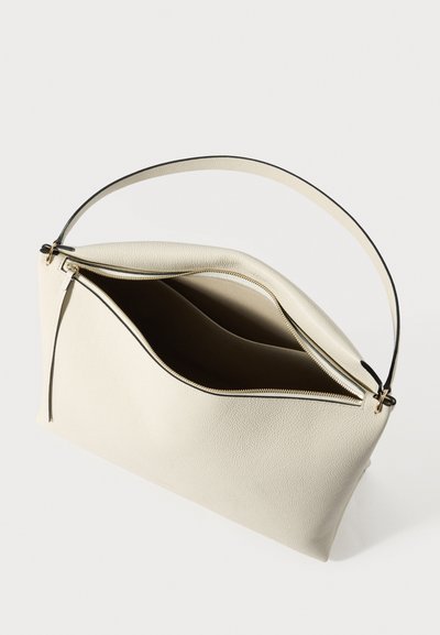 Bézs bőrtáska egy vállpánttal, nyitott cipzárral, amely két belső rekeszt tár fel, aranyszínű fém kiegészítőkkel.