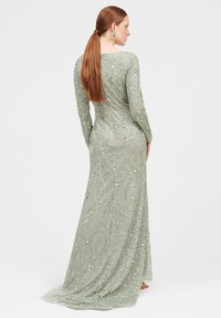 Langärmliges, bodenlanges Kleid in Hellgrün mit aufwendiger Perlenstickerei und Pailletten. Hat eine figurbetonte Silhouette und einen fließenden Schleppe.