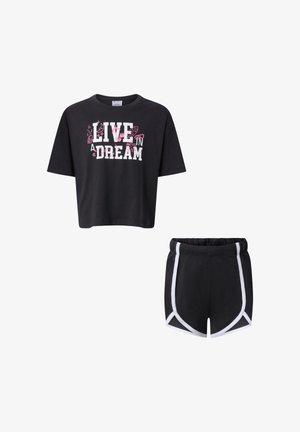 T-shirt nera corta con scritta "Live in a Dream" e dettagli rosa abbinata a pantaloncini sportivi neri con bordino bianco e vita elastica.