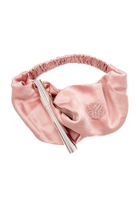Un élastique à cheveux en satin rose avec un bandeau plissé, orné d'un grand nœud et d'un détail floral brodé, accompagné d'un stylo cosmétique en argent.