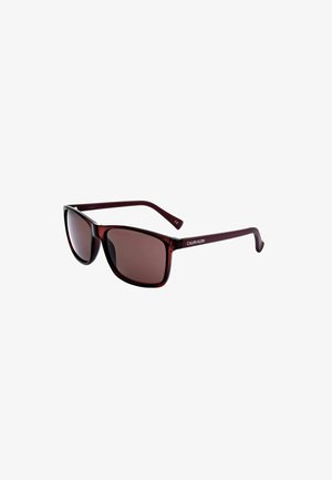 Occhiali da sole rettangolari Calvin Klein di colore rosso scuro con lenti sfumate e aste sottili, mostrati leggermente inclinati su sfondo bianco.