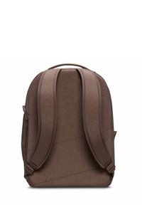 Mochila marrón con una superficie lisa y texturizada, que presenta correas de hombro acolchadas y un asa en la parte superior. Diseño minimalista con costuras diagonales.