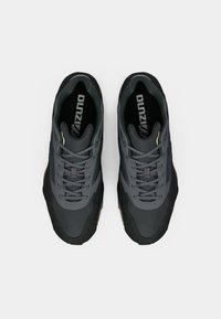 Gray athletic shoes with mesh and suede material, featuring a textured sole, contrasting black accents, and a branded insole.