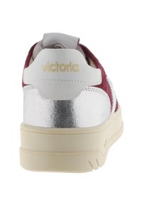 Sneakers in suede rosso e pelle bianca con dettagli metallici argento. Presentano il marchio "victoria" e un design della suola testurizzato.