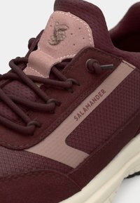 Μαρόν αθλητικό παπούτσι με υφές από δίχτυ και σουέντ, ροζ λεπτομέρειες, εντυπωσιακό σύστημα κορδονιών και λογότυπο "SALAMANDER" στο πλάι.