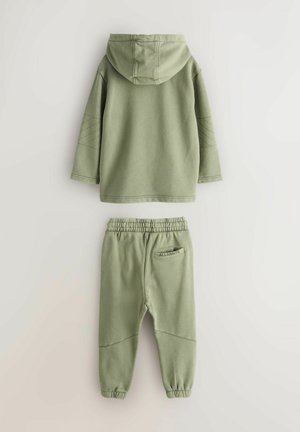 Olivgrüner Kapuzenpullover mit gesteppten Details an den Ärmeln. Passende Jogginghose mit elastischem Bund und Logo auf der Gesäßtasche.