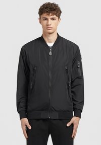 Schwarze Bomberjacke mit einem Reißverschluss vorne, gerippten Bündchen und zwei seitlichen Reißverschlusstaschen. Hergestellt aus glattem, leichtem Stoff mit einem minimalistischen Design.