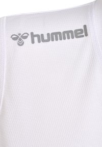 Hvid sports tanktop med ribbet tekstur, prydet med grå "hummel" logo på skulderen. Enkel design, ærmeløs konstruktion.