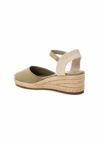 Espadrilles de ante beige con plataforma de yute trenzado. La correa ajustable presenta un patrón de cuadros. Punta redondeada, textura rugosa y base sólida.