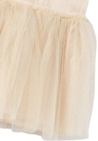 Gonna tutu beige pallido realizzata in tulle stratificato, con una morbida vita arricciata e una leggera lucentezza su tutto il tessuto.