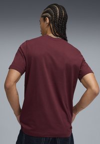 Bordeaux t-shirt med korte ærmer og rund halsudskæring. Glat bomuldsstof. Bagsiden viser en tydelig silhuet og afslappet pasform.
