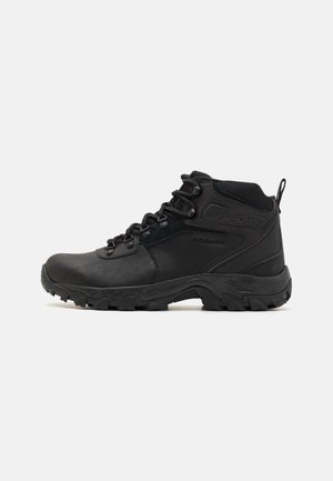 Zwarte wandelschoenen gemaakt van synthetisch materiaal met een gestructureerd oppervlak, vetersluiting, gevoerde kraag en een robuuste zool voor grip.