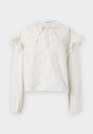 Blouse blanche à manches longues avec broderie œillets, épaules à volants, encolure fendue avec lien, et poignets élastiques.