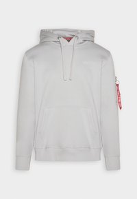 Sudadera con capucha gris, con un bolsillo frontal, puños acanalados y un bolsillo con cremallera en la manga que incluye una lengüeta de tirador roja. Textura de tela suave.