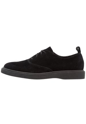 Schwarzer Wildleder-Tiefschnitt-Schnürschuh mit abgerundetem Zehenbereich, Zuglasche an der Ferse und dicker Gummisohle.