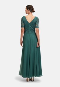 Robe de soirée en teal avec corsage en dentelle et manches courtes, design dos en V, jupe en chiffon fluide et éclat subtil.