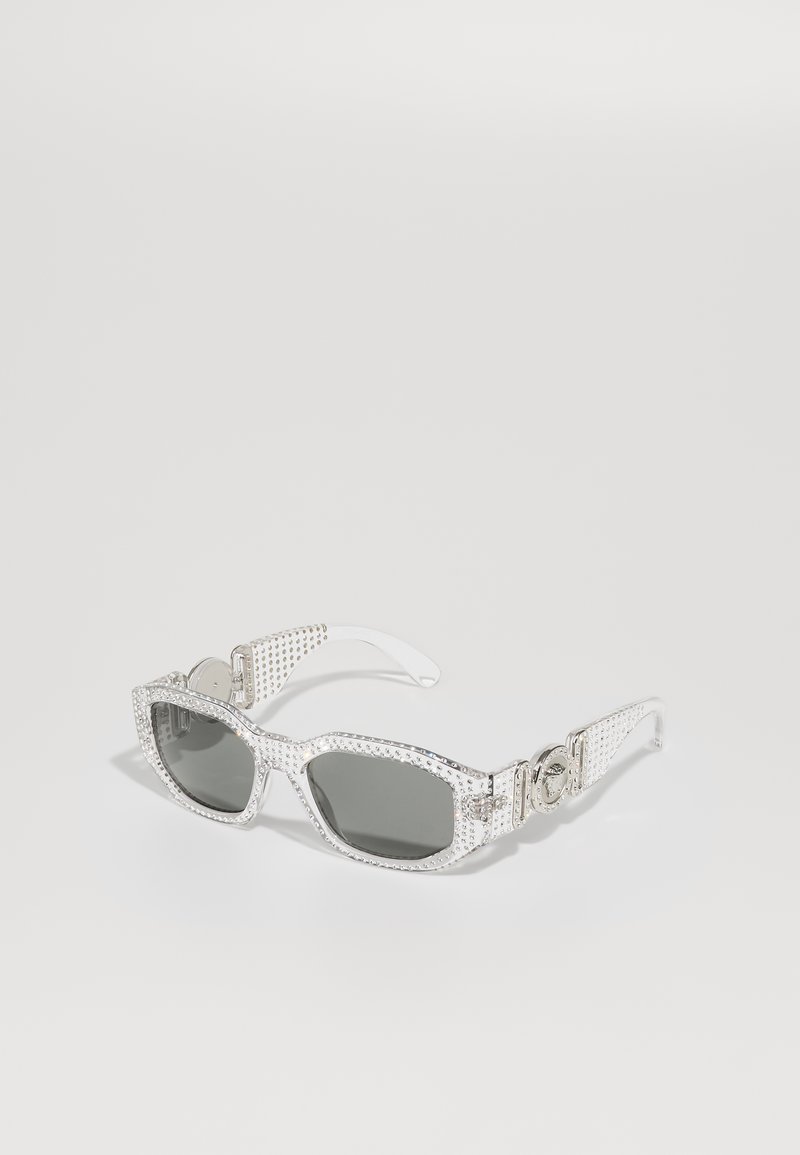 Silver sunglasses with a rectangular frame, grey lenses, studded accents, and decorative side hardware. Glossy finish with textured arms.