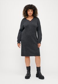 Charcoal gray knit dress with a V-neckline, long sleeves, and ribbed hem, paired with black chunky ankle boots.