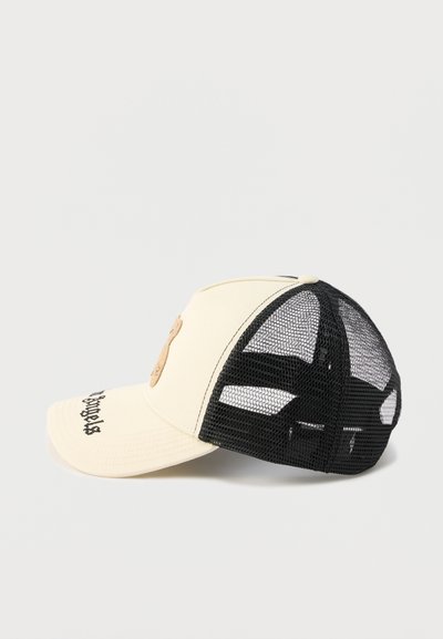 Κρεμ μπροστινό καπέλο με μαύρο πλέγμα στην πίσω πλευρά, με κεντημένο κείμενο στο γείσο και ένα μικρό πατς στο μπροστινό πάνελ.