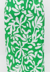 Grön tyg med ett djärvt vitt bladmönster, utformat med en slät textur och flödande form, lämpligt för sommarplagg.