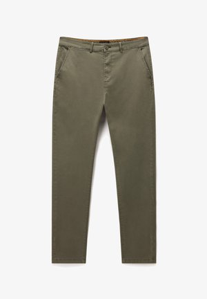 Olivově zelené bavlněné chino kalhoty s hladkou texturou, slim fit, předními kapsami a zipovým zapínáním. Obsahují kontrastní detail vnitřního pásu.