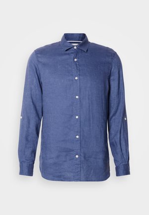 Chemise en lin bleue à manches longues avec col boutonné et fermeture à boutons sur le devant. Texture douce avec détail des manches retroussées et légère brillance.