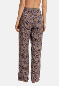 Wijdvallende broek in een paarse en beige bloemenprint, met een elastische tailleband en een gladde stofstructuur.