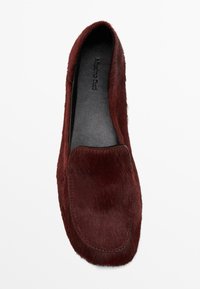 Scarpa piatta bordeaux con una morbida texture in pelliccia sintetica, punta tonda e un semplice design cucito. La soletta interna è in pelle nera.
