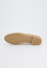 Béžová semišová podrážka boty s hladkým povrchem, zaoblenou špičkou a decentním logem. Flexibilní konstrukce pro pohodlí.