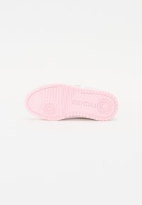 Sole of a sneaker featuring a textured design with a light pink rubber outsole and embossed branding, complementing a clean white upper.