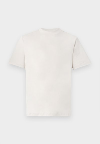 Απλή λευκή κοντομάνικη μπλούζα με στρογγυλή λαιμόκοψη, απλωμένη επίπεδη σε λευκό φόντο.