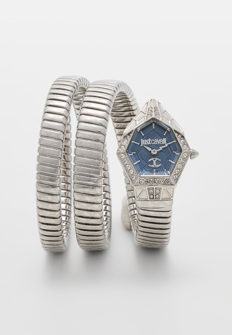 Montre en argent avec un cadran hexagonal, fond bleu, orné de strass ; présente un design de bracelet flexible et strié.