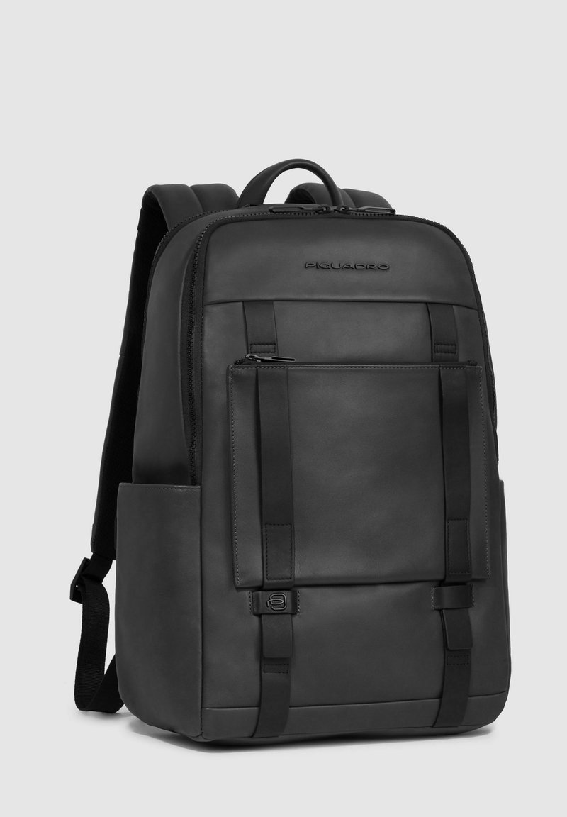 Sac à dos en cuir noir avec des bretelles ajustables, poche zippée à l'avant, design minimaliste et coutures renforcées. Texture lisse avec finition mate.