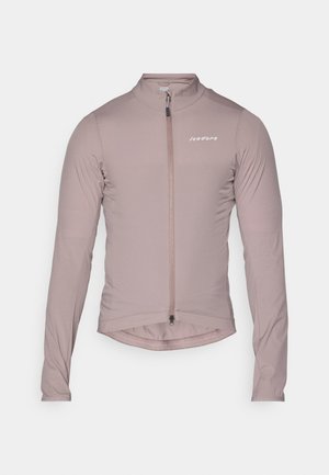 Light pink long-sleeve cycling jacket in stretchy fabric, featuring a front zipper and a slightly curved hem. Minimal branding on the chest.