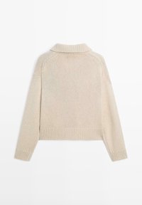 Beige knitted sweater with a high collar, ribbed cuffs, and hem. Features a textured pattern and raglan sleeves for a relaxed fit.