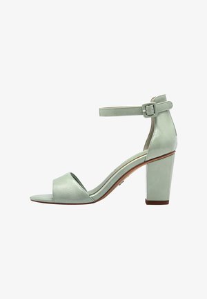 Μέντα πράσινη ψηλή σαγιονάρα με ανοιχτό δάχτυλο, λουράκι στον αστράγαλο με πόρπη και χοντρό τακούνι. Λείος υφή με ελαφριά γυαλάδα και μινιμαλιστικός σχεδιασμός.