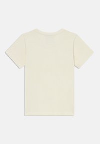 Šviesiai smėlinės spalvos trumpomis rankovėmis marškiniai, turintys paprastą apvalią iškirptę ir lygią tekstūrą, be matomų grafinių elementų ar papuošimų.